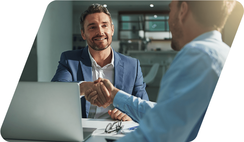 Two men shaking hands in an office.