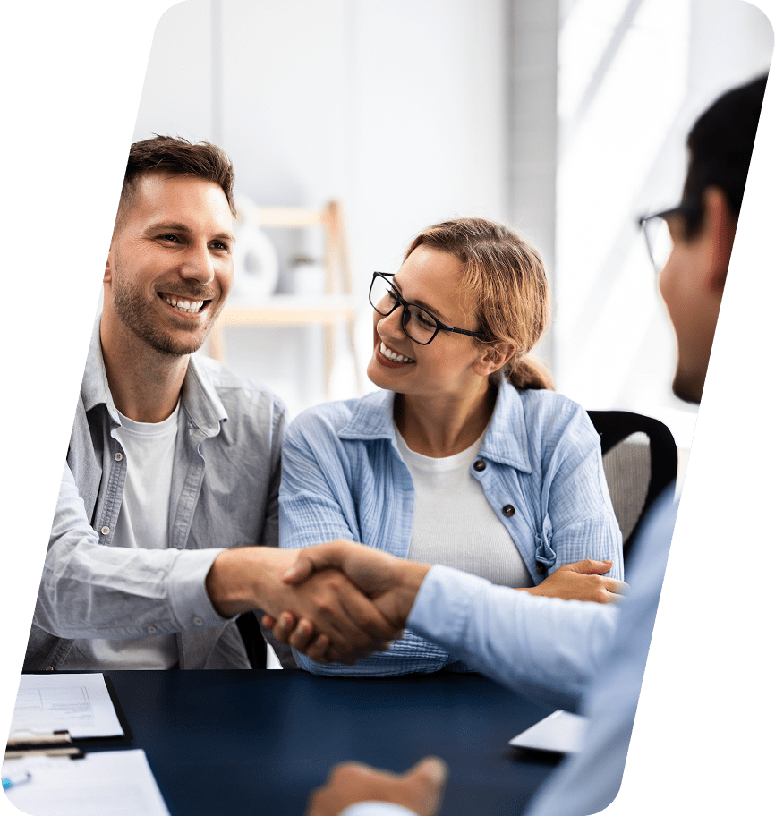 Smiling couple shaking hands with professional.